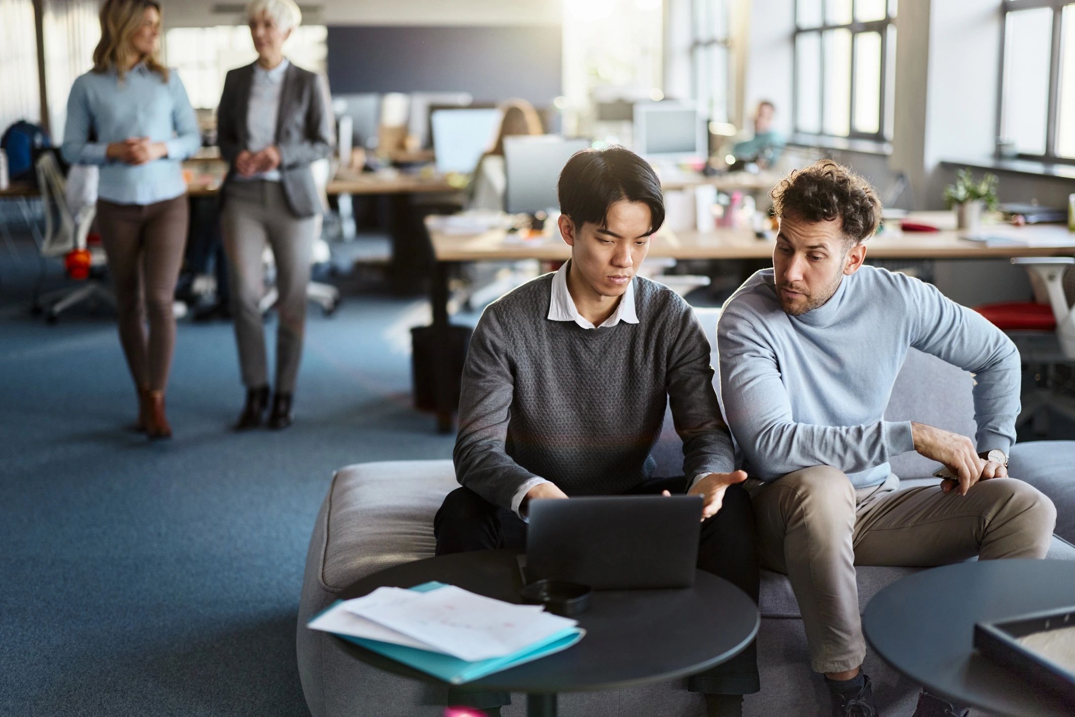 Professionals working together on a laptop in an office