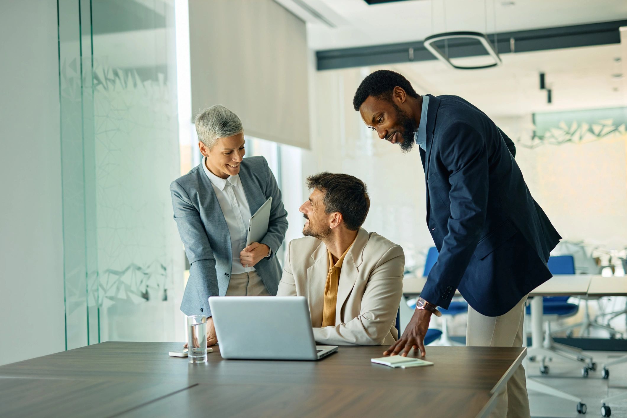Business professional collaborating with team around a laptop